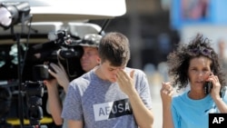 Nicole Auzston, right, and son Branden, 17, a junior who was at the school when the shooting took place, react outside the unification center at the Alamo Gym, following a shooting at Santa Fe High School, May 18, 2018, in Santa Fe, Texas.