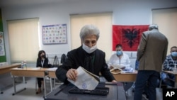A woman casts her ballot during parliamentary elections in capital Tirana, Albania, April 25, 2021. 