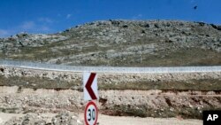 FILE - A newly built wall near Cilvegozu border gate in Reyhanli, at the Turkey-Syria border, May 24, 2017. Turkish President Recep Tayyip Erdogan says his country plans to build walls along its borders with Iraq and Iran, similar to the one currently being erected along the frontier with Syria.