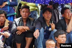 Men watch horse racing held during the Torch Festival celebrated by ethnic Yi minorities in Butuo County, Sichuan province, China, July 22, 2017.