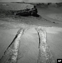 NASA's Mars Exploration Rover Opportunity climbed out of "Victoria Crater" following the tracks it had made when it descended into the 800-meter-diameter (half-mile-diameter) bowl nearly a year earlier.