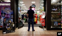 FILE - A 27-year-old self-described tech addict poses for a portrait in front of a video game store at a mall in Everett, Wash., Dec. 9, 2018.