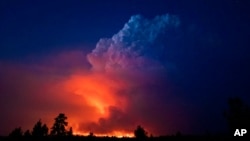 In this photo provided by the Oregon Office of State Fire Marshall, flames and smoke rise from the Bootleg Fire in southern Oregon on July 14, 2021.
