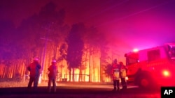 FILE - Firefighters battle a wildfire at Wooroloo, near Perth, Australia, Feb. 1, 2021. 