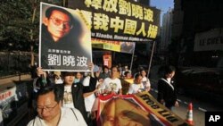 Pro-democracy protesters with banners bearing photos of jailed Chinese dissident Liu Xiaobo march to the Chinese government liaison office in Hong Kong, 05 Dec 2010