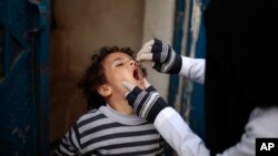 FILE - A Yemeni health worker administers a dose of polio vaccine to a boy during a house-to-house immunization campaign in Sana'a, Yemen, Feb. 21, 2017.
