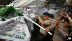 Polisi melemparkan gas air mata untuk membubarkan demonstran yang memrotes film 'Innocence of Muslims' di depan Kedutaan Besar AS di Jakarta. (AP/Dita Alangkara)