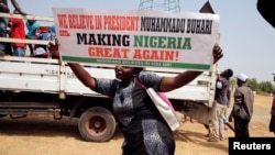 A woman holds a placard during a rally to show support for Nigeria's President Muhammadu Buhari in Abuja, Nigeria, Feb. 6, 2017. 