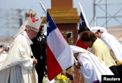 FILE - Pope Francis is greeted by faithful during an offertory as he celebrates a Mass at Lobito beach in Iquique, Chile, Jan. 18, 2018.