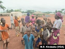 CAR refugee children at Garoua Boulaye play with a host parent.