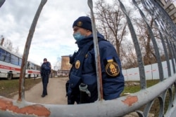 Ukrainian National Guard servicemen patrol by the gate of a military medical facility where evacuees from coronavirus-hit China are quarantined, in the town of Novi Sanzhary, Poltava region, Ukraine, Feb. 21, 2020.