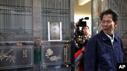 File Photo shows Lin Zuluan, a representative from the village of Wukan in Lufeng county, Guangdong province, followed by members of the international media as he leaves his home, December 21, 2011