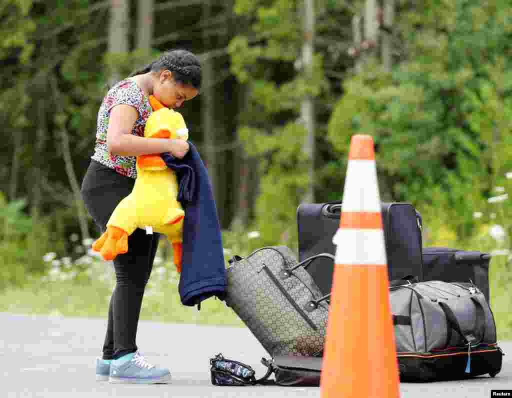 A young girl whose family said they were from Syria gathers her belongings at the US-Canada border in Champlain, New York, Aug. 7, 2017.