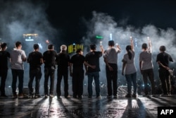 A group of veteran pro-democracy activists hold candles during a candlelight vigil at Victoria Park in Hong Kong, June 4, 2019.