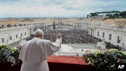 Paus Fransiskus menyapa jemaat yang hadir dalam pemberkatan Hari Natal dari balkon Basilika santo Petrus di Vatikan, pada 25 Desember 2023. (Foto: Vatican Media via AP)