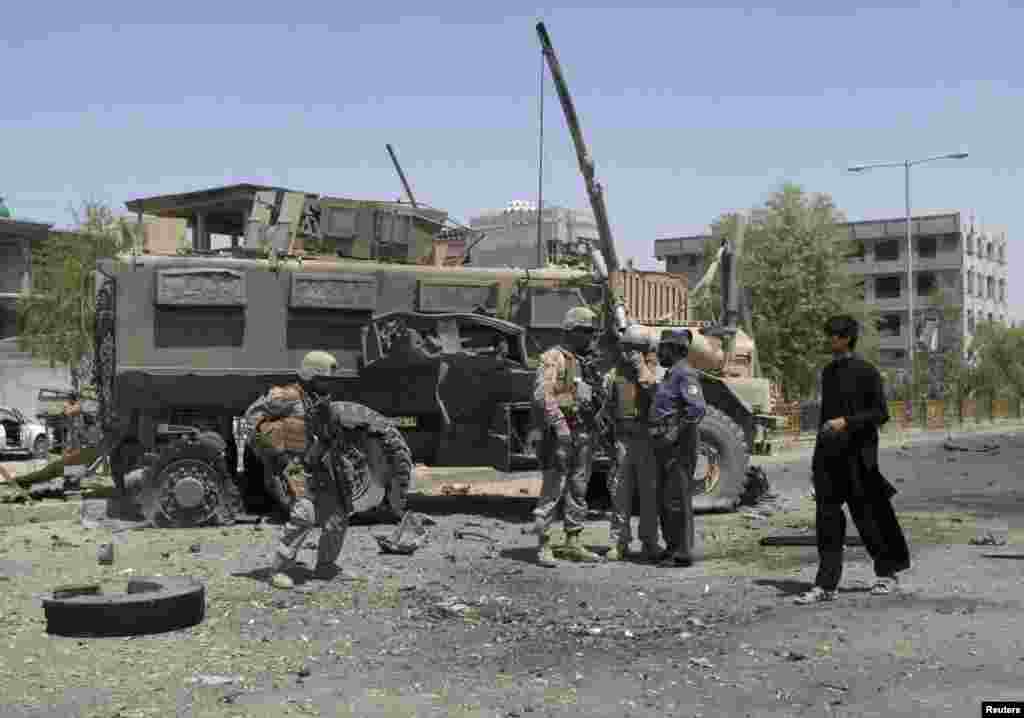 NATO soldiers stand at the site of an attack in Helmand province, Afghanistan, August 28, 2013. 