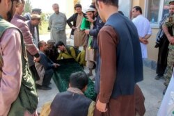 FILE - Relatives gather next to the coffin of a soldier after an ambush blamed on the Taliban killed at least 25 Afghan security force personnel as spiraling violence imperils ongoing peace talks, in Takhar province, Oct. 21, 2020.
