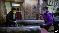 Attendants of a patient carry an oxygen cylinder inside a hospital in Srinagar, Indian-controlled Kashmir, April 25, 2021.