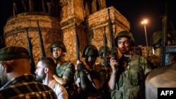 Turkish solders stay with weapons at Taksim Square as people protest against the military coup in Istanbul, July 16, 2016. 
