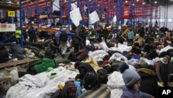 Migrants settle in a logistics center at the checkpoint "Kuznitsa" at the Belarus-Poland border near Grodno, Belarus, on Nov. 19, 2021.