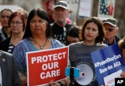 State Sen. Dr. Irene Aguilar, D-Denver, left, stands with activist Christina Postolowski, of the group Young Invincibles, as supporters of the Affordable Care Act who are also opponents of Colorado's GOP-led plan to undo Colorado's state-run insurance.