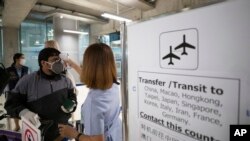 A health worker checks tourists' temperatures as they arrive at Suvarnabhumi Airport, in Bangkok, Thailand, March 4, 2020. 