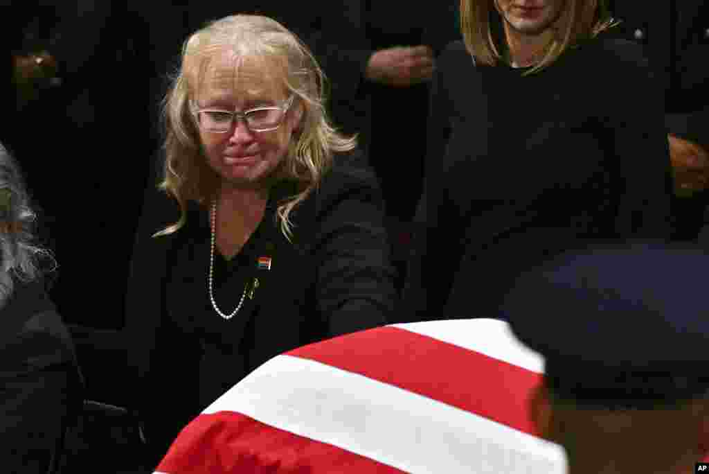 Amy Carter touches the flag-draped casket of her father, former President Jimmy Carter, after a ceremony where Carter lies in state at the Capitol in Washington, Jan. 7, 2025. 