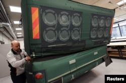 A worker prepares an inflatable decoy of a military vehicle, which is used to confuse enemy attacks, during a media presentation in Decin, Czech Republic, March 6, 2023.