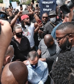 Joined by community faith leaders Los Angeles Mayor Eric Garcetti takes a knee in prayer during a Black Lives Matter protest in downtown Los Angeles, Tuesday, June 2, 2020.