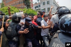 Nepalese protestors shout slogans against the government as they are stopped by police on the first anniversary of the devastating earthquake in Kathmandu, Nepal, April 24, 2016.