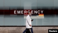 FILE - A doctor wears a protective mask as he walks outside Mount Sinai Hospital in Manhattan during the outbreak of coronavirus in New York City, April 1, 2020. 