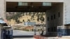 FILE - A road sign that reads "Welcome to Bab al-Hawa crossing" is seen at Bab al-Hawa crossing at the Syrian-Turkish border, in Idlib governorate, Syria, June 10, 2021. 