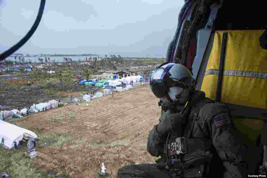 A Naval Aircrewman prepares to drop supplies, Tacloban, Philippines, Nov. 14, 2013. (U.S. Navy)