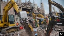 Para pekerja dan tentara menggunakan peralatan berat untuk membersihkan reruntuhan gedung pabrik garmen di Savar dekat Dhaka, Bangladesh dan meneruskan pencarian jenazah korban (6/5). 