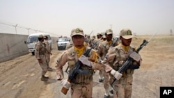 FILE - A group of Iranian border guards march at the eastern border of Iran shared with Pakistan and Afghanistan, near Zabol, Sistan-Baluchistan Province, Iran, July 19, 2011.