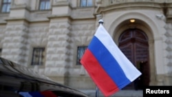 Bendera nasional Rusia terlihat di sebuah mobil yang terparkir di Kementerian Luar Negeri di Praha, Republik Ceko, 21 April 2021. (Foto: David W. Cerny/Reuters)