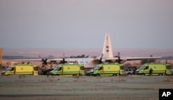 Ambulances line up as emergency workers unload bodies of victims from the crash of a Russian aircraft over the Sinai peninsula at the Kabrit military airport, some 20 miles north of Suez, Egypt, Oct. 31, 2015.