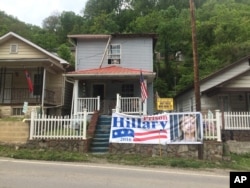 Brenda Horvath displays a large sign that reads, "Hillary for Prison 2016," on the front of her home in Logan, West Virginia, May 10, 2016. A registered Democrat who comes from long line of coalminers, she says she's supporting Donald Trump. "When I was growing up, it was a big to-do to change from Democrat to Republicans. Now, I don't see any difference. ... They'll all out for themselves."