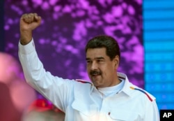 FILE - Venezuela's President Nicolas Maduro pumps his fist during a pro-government demonstration in Caracas, Venezuela, Feb. 12, 2019.