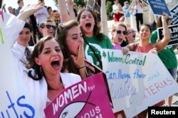 FILE - Anti-abortion demonstrators cheer as the ruling for Hobby Lobby regarding contraceptives coverage was announced outside the U.S. Supreme Court in Washington, June 30, 2014.