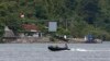 FILE - Indonesian military patrol in a small inflatable boat near a ferry boat dock on the prison island of Nusakambangan, in the background, in Central Java. March 3, 2015. Aman Abdurrahman is being held at Nusakambangan.