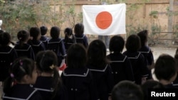 Students line up in front of Japan's national flag at the morning assembly at Tsukamoto kindergarten in Osaka, Japan, Nov. 30, 2016. 
