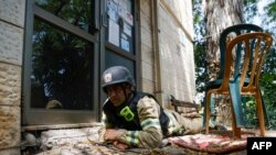 Seorang petugas pemadam kebakaran Israel berlindung di Kiryat Shmona di utara Israel, di saat sirene berbunyi yang menandakan ada peluncuran roket dari wilayah selatan Lebanon, pada 19 Juni 2024. (Foto: AFP/Jalaa Marey)