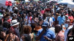 FILE - A crowd of people take part in a Juneteenth commemoration at Leimert Park Plaza in Los Angeles on June 19, 2021.