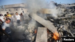People gather as a Palestinian man reacts next to the rubble of his house, which witnesses said was destroyed in an Israeli air strike, in Rafah in the southern Gaza Strip, Aug. 20, 2014.