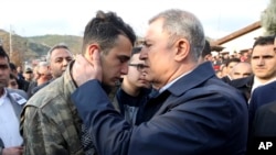Turkish Defense Minister Hulusi Akar speaks with the brother of Halil Ibrahim Akkaya, one of 33 Turkish troops killed in Syria’s Idlib region during airstrikes, in Bahce, Osmaniye, Turkey, Feb. 28, 2020.