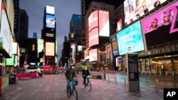 People ride bicycles in New York's Times Square on April 29, 2020, during the coronavirus pandemic.