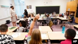FILE - A student raises their hand in a classroom at Tussahaw Elementary school Aug. 4, 2021, in McDonough, Georgia.