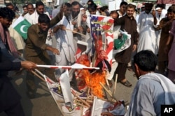 FILE - Pakistani protesters burn posters of U.S. President Donald Trump in Peshawar, Pakistan, Aug. 30, 2017. Protesters have objected to Trump's allegation that Islamabad is harboring militants who battle U.S. forces in Afghanistan.