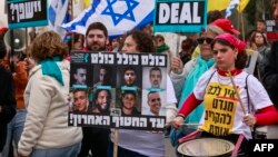 ২০২৩ সালের অক্টোবর থেকে গাজা ভূখণ্ডে জিম্মি হয়ে থাকা ইসরায়েলিদের সমর্থকরা প্রধানমন্ত্রীর দফতরের সামনে এক সমাবেশে প্ল্যাকার্ড ও পতাকা তুলে ধরেছেন। জেরুজালেম। ফটোঃ ১১ ফেব্রুয়ারি, ২০২৫।
